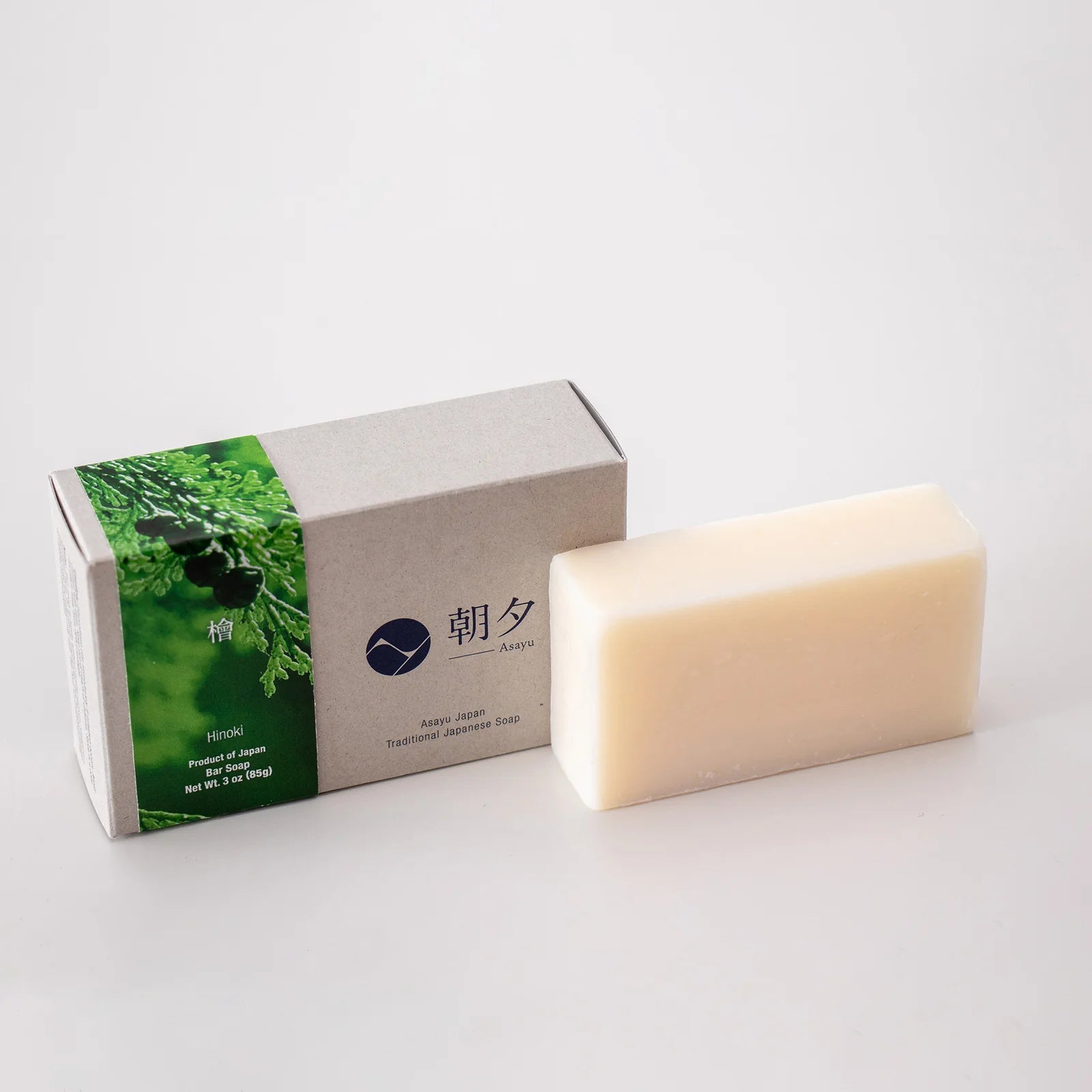 Bar of soap next to its packaging on a white background
